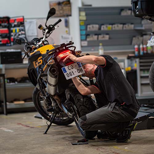 mécanicien qui répare une moto