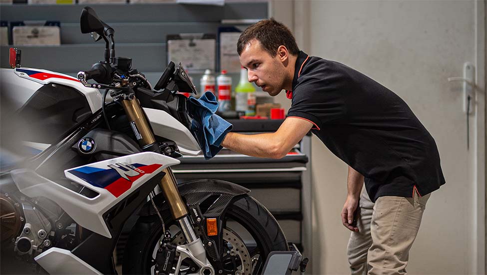 mécanicien qui nettoie une moto