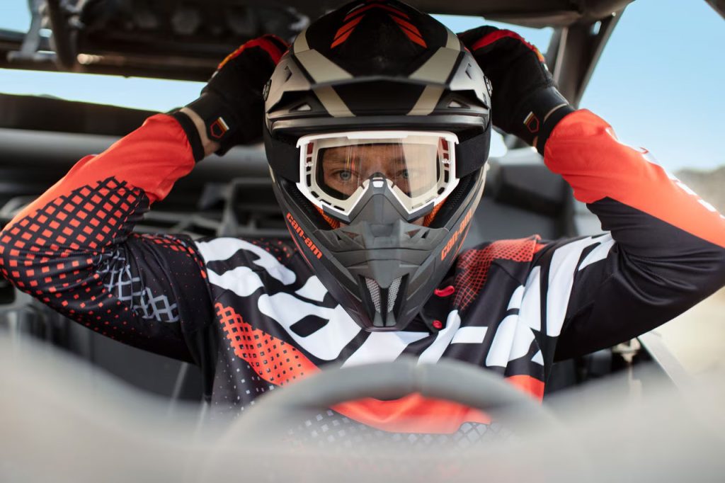 Pilote avec casque cross et masque dans un buggy Can-Am