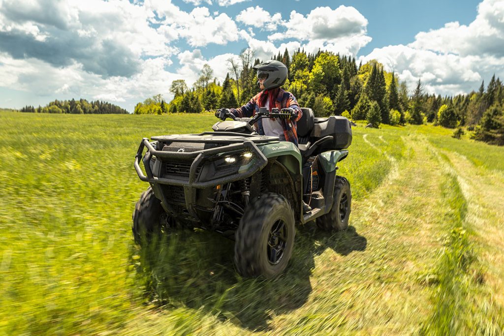 Conductrice sur un Can-Am Outlander Pro dans une prairie